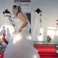 Model in weißem Brautkleid tanzt über den Laufsteg