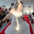 Model in weißem Brautkleid tanzt über den Laufsteg