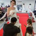 Bräutigam kniet vor der Braut und hebt das Kleid an