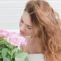 Simone riecht an einem Strauß rosafarbener Rosen