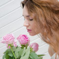 Simone inhaliert den Duft von rosafarbenen Rosen